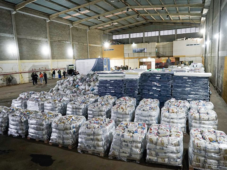 Galpão com cestas básicas embaladas e empilhadas em paletes