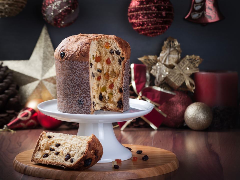 Panetone fatiado sobre a mesa com enfeites de Natal